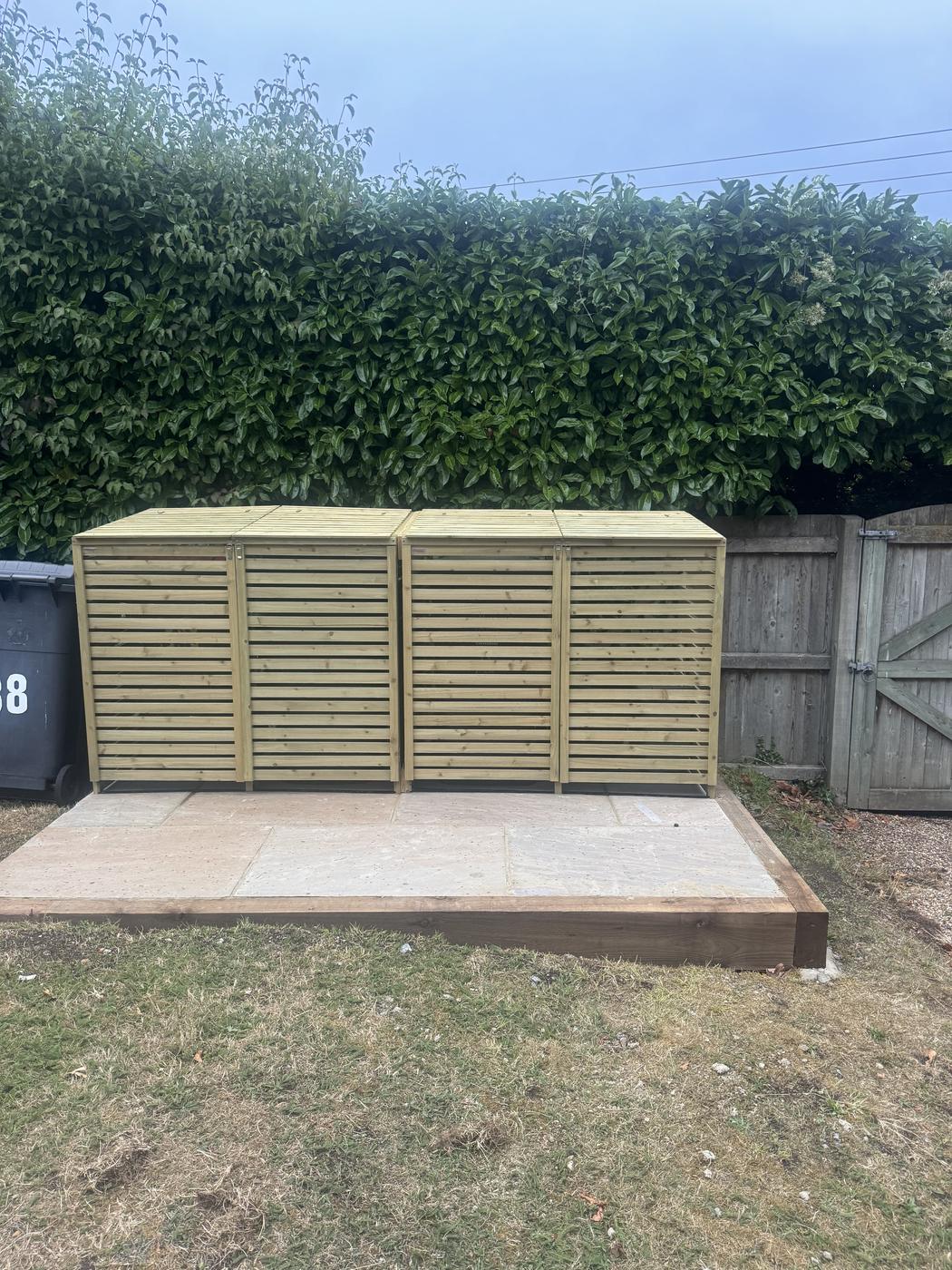 Slatted timber bin storage unit on a paved base