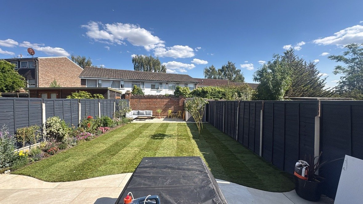 Finished lawn with mowing stripes, borders and seating area after a garden renovation